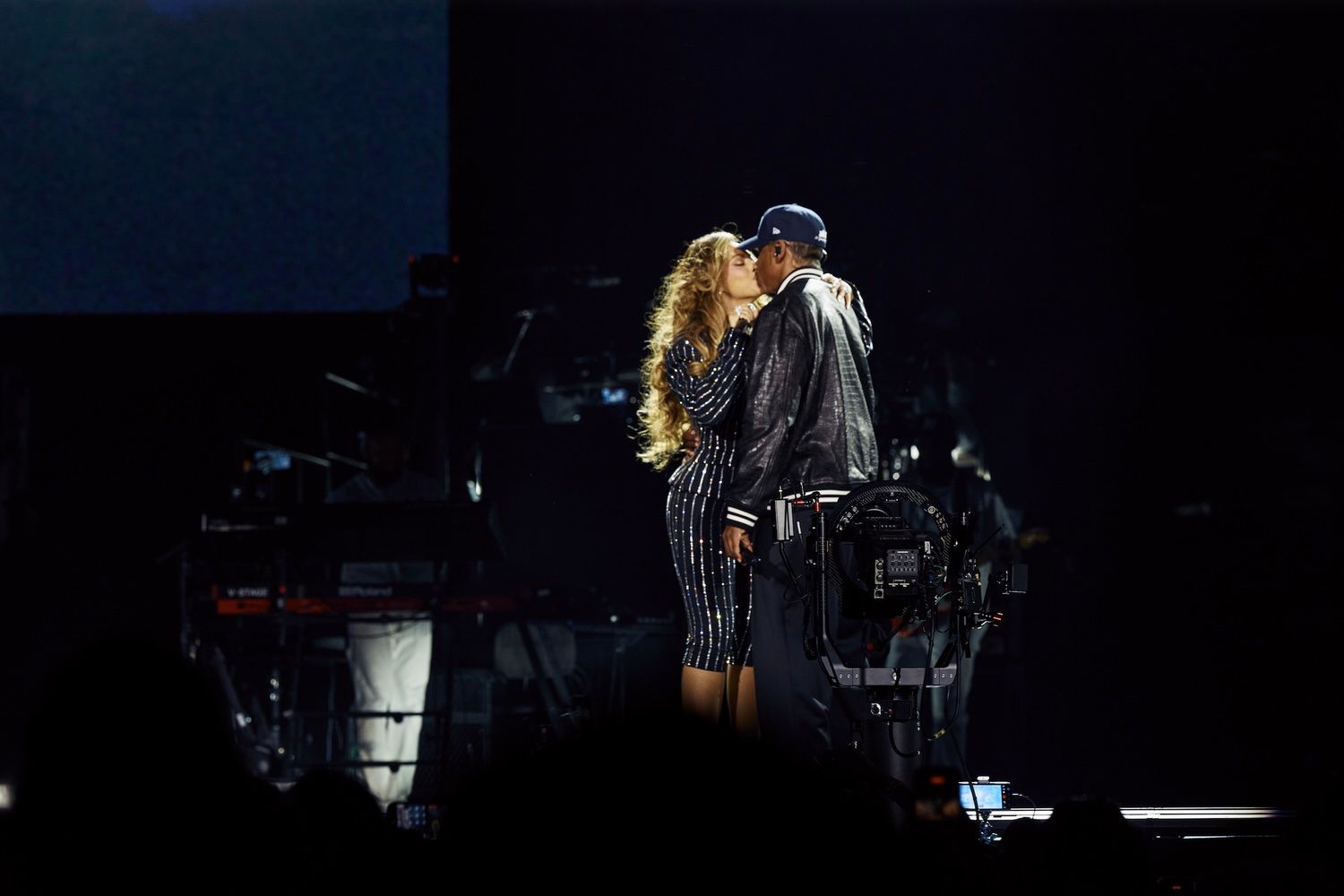 Image may contain Lighting Adult Person Kissing Romantic Clothing Hat Coat Computer Hardware and Electronics